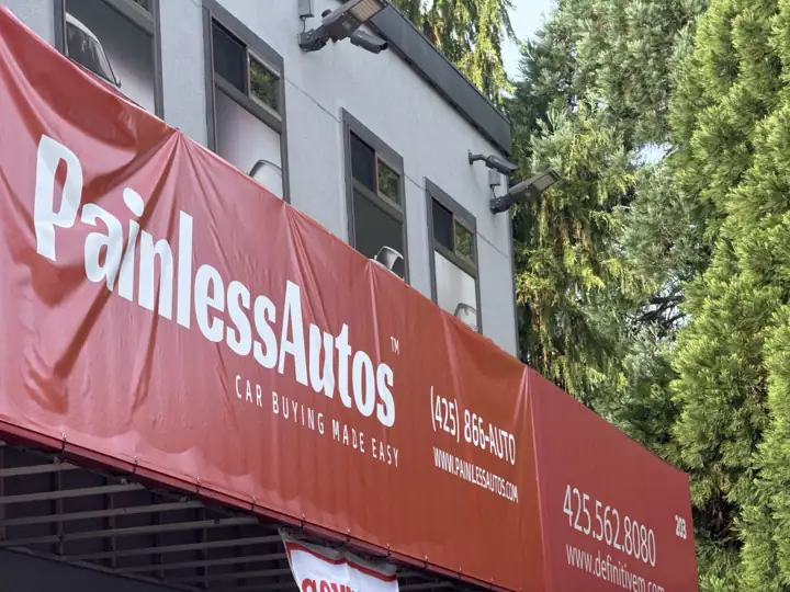 The Painless Autos storefront with its red sign